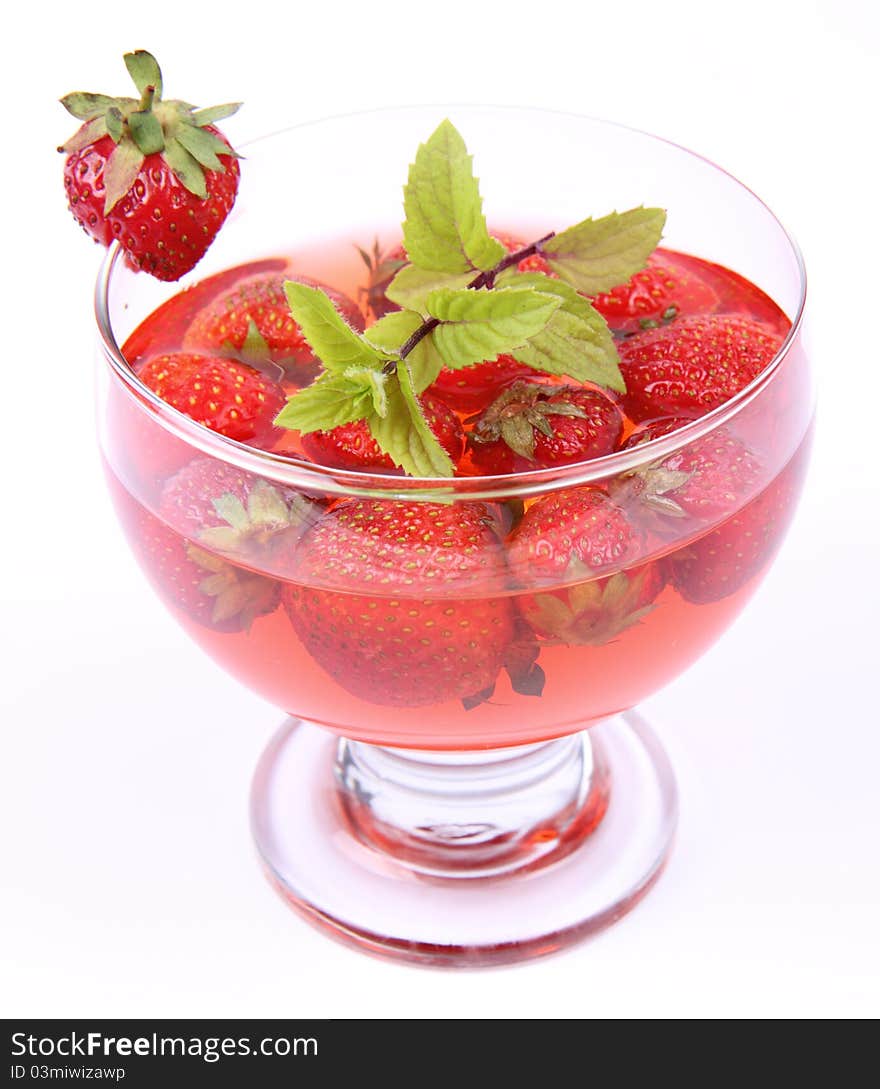 Jelly with strawberries decorated with a mint twig in a glass cup. Jelly with strawberries decorated with a mint twig in a glass cup