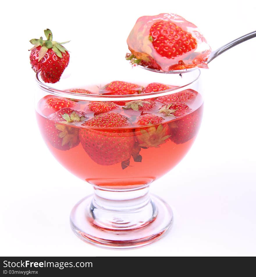 Jelly with strawberries being eaten with a spoon. Jelly with strawberries being eaten with a spoon