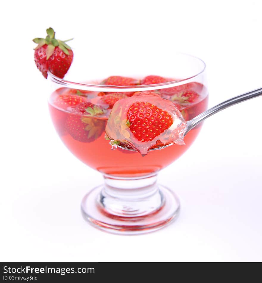 Jelly with strawberries being eaten with a spoon. Jelly with strawberries being eaten with a spoon