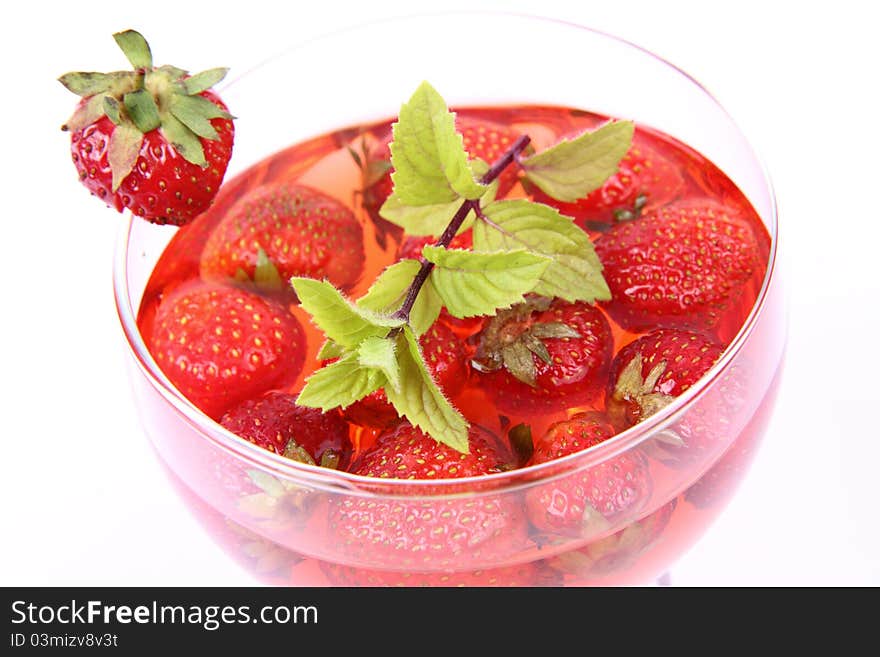 Jelly with strawberries decorated with a mint twig in a glass cup. Jelly with strawberries decorated with a mint twig in a glass cup