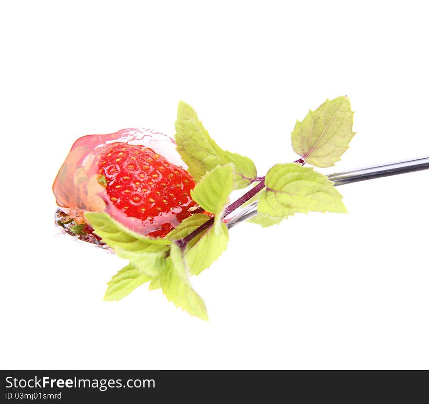 Jelly with a strawberry on a spoon decorated with mint on white background. Jelly with a strawberry on a spoon decorated with mint on white background