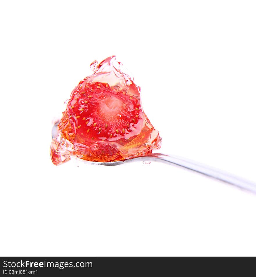 Jelly with a strawberry on a spoon on white background. Jelly with a strawberry on a spoon on white background