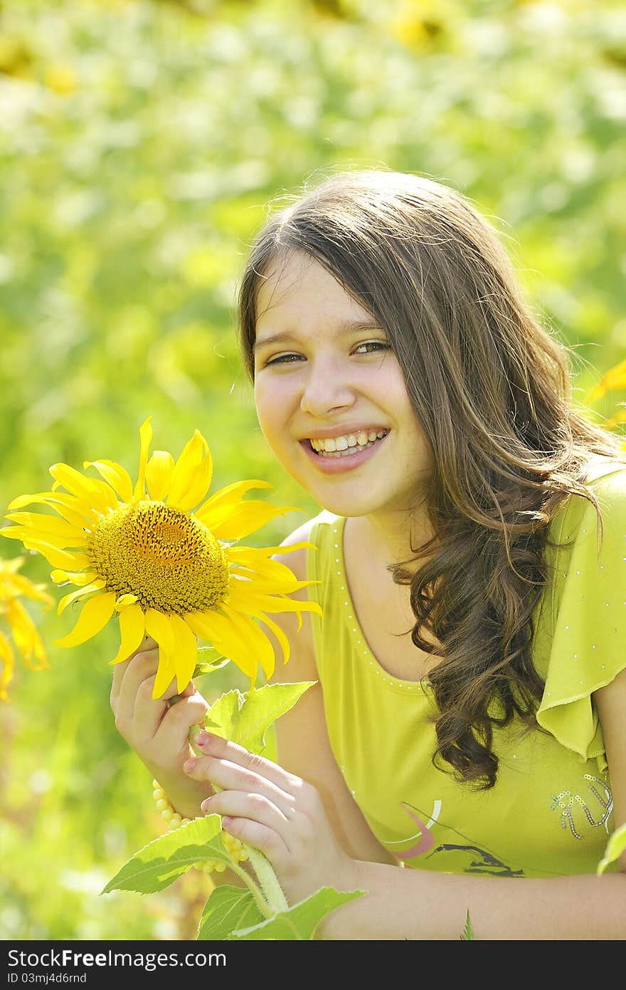 Beauty teen girl and sunflowers in summer time