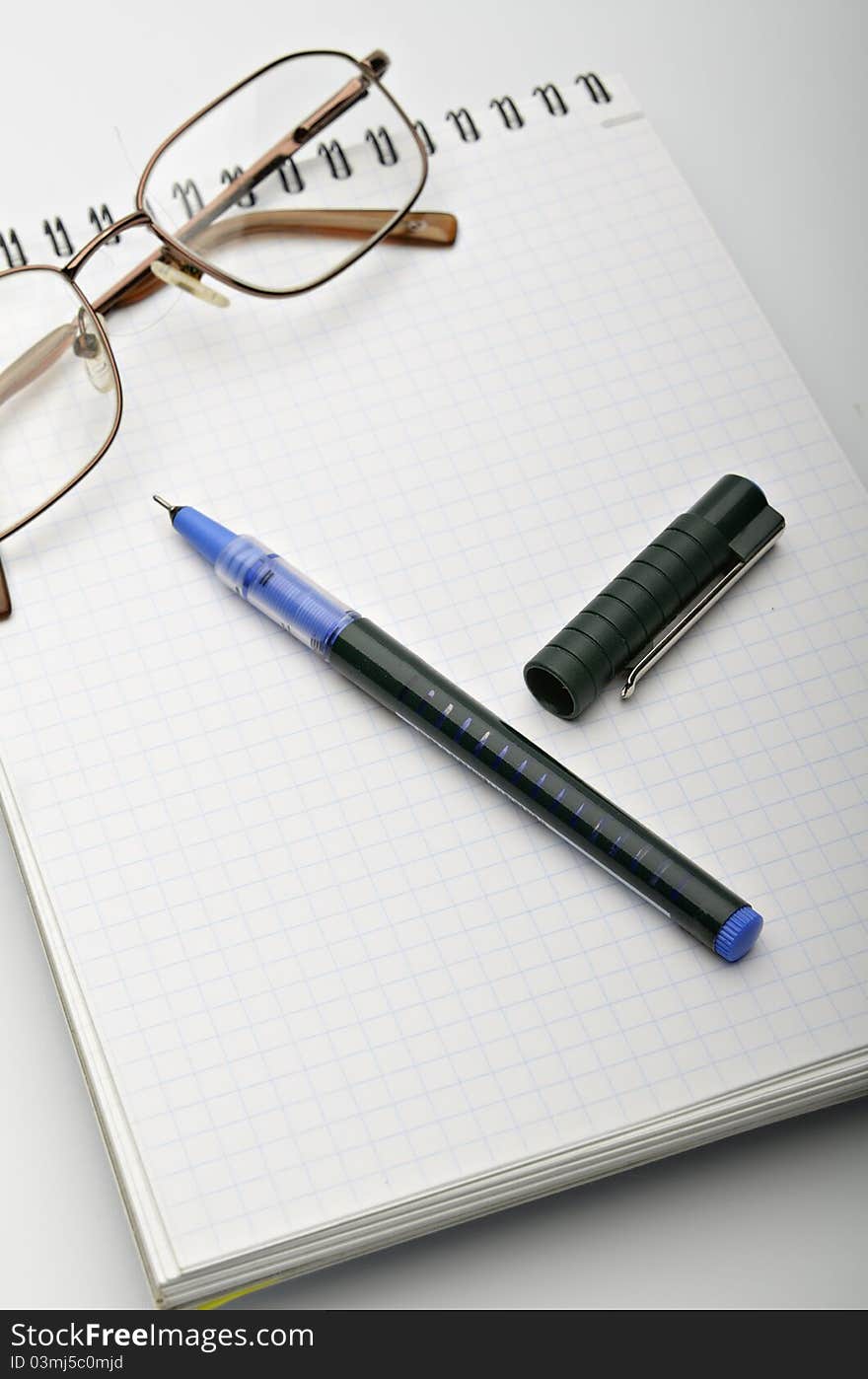 Notebook and pen on a light grey background