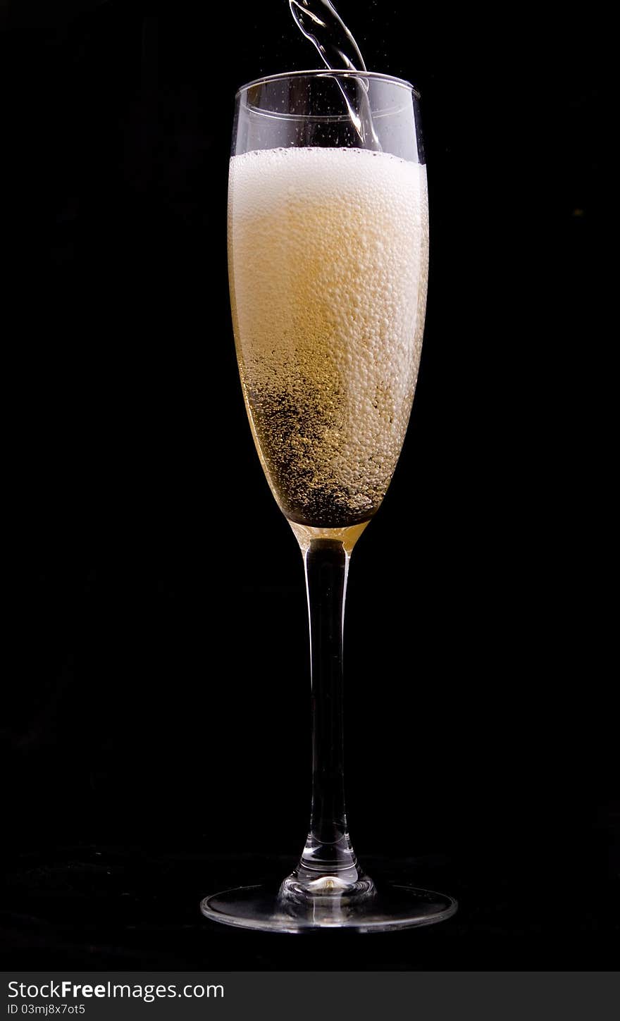 Wine being poured into a glass on black background