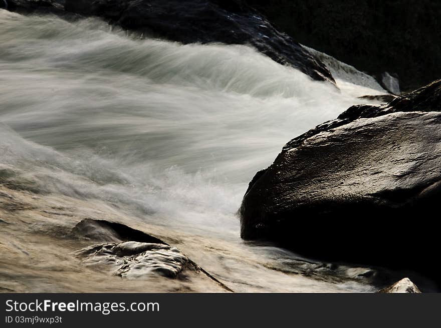 The photo depicts the fast flowing waters of Teesta, a small Himalayan river amidst rocky boundaries. The photo depicts the fast flowing waters of Teesta, a small Himalayan river amidst rocky boundaries.