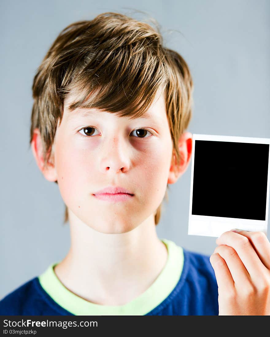 A teenager holding a blank polaroid photograph. A teenager holding a blank polaroid photograph