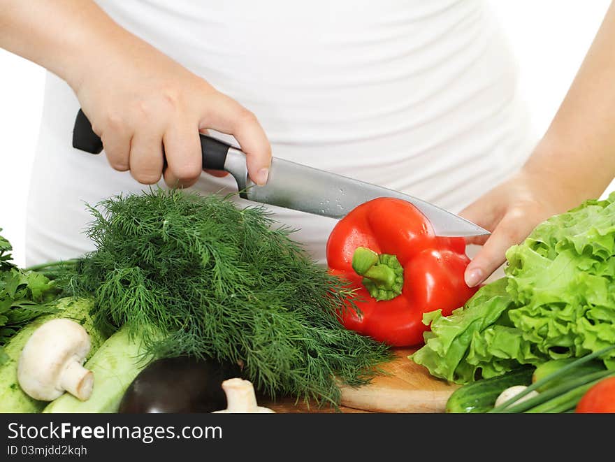 Woman's hands cutting vegetablesat the kitchen