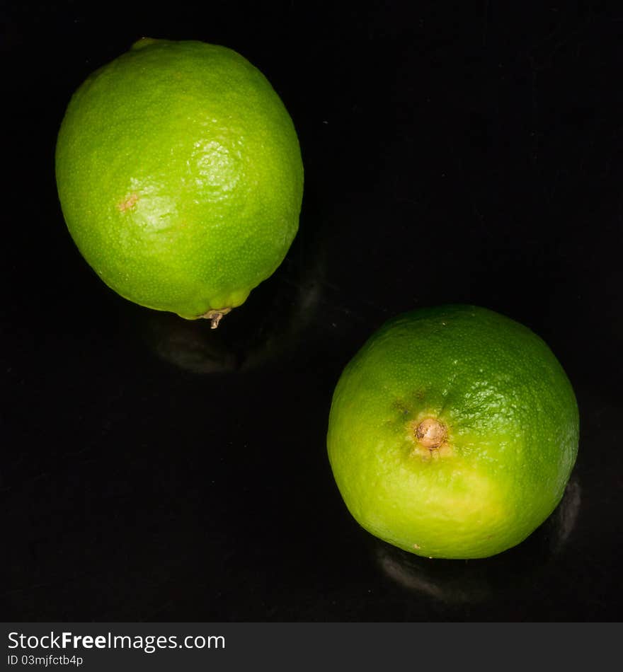 Two limes on a black background