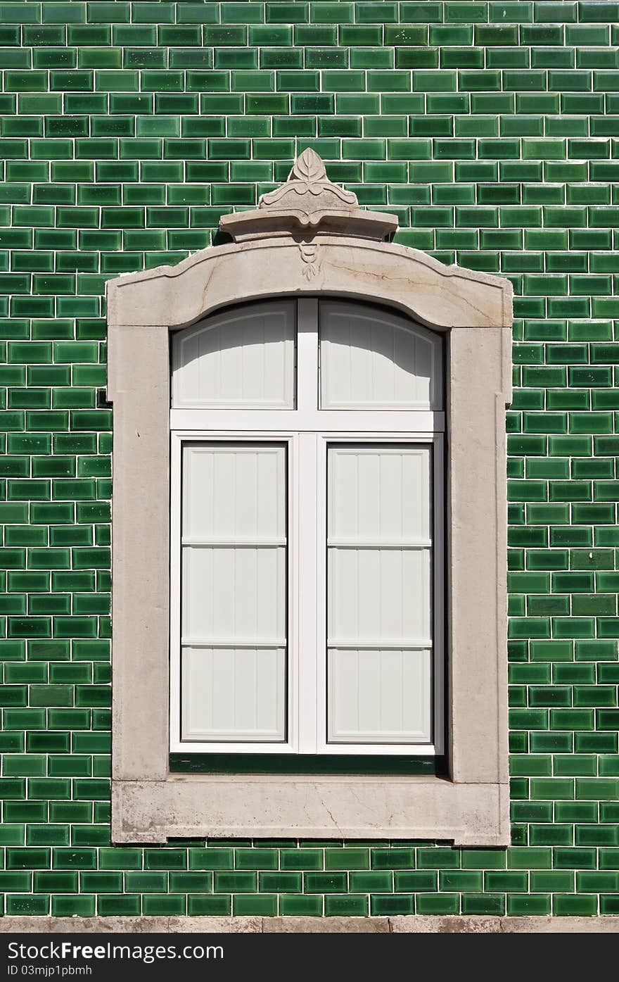 Traditional stone decorated window in a green tile background, Algarve, Portugal. Traditional stone decorated window in a green tile background, Algarve, Portugal