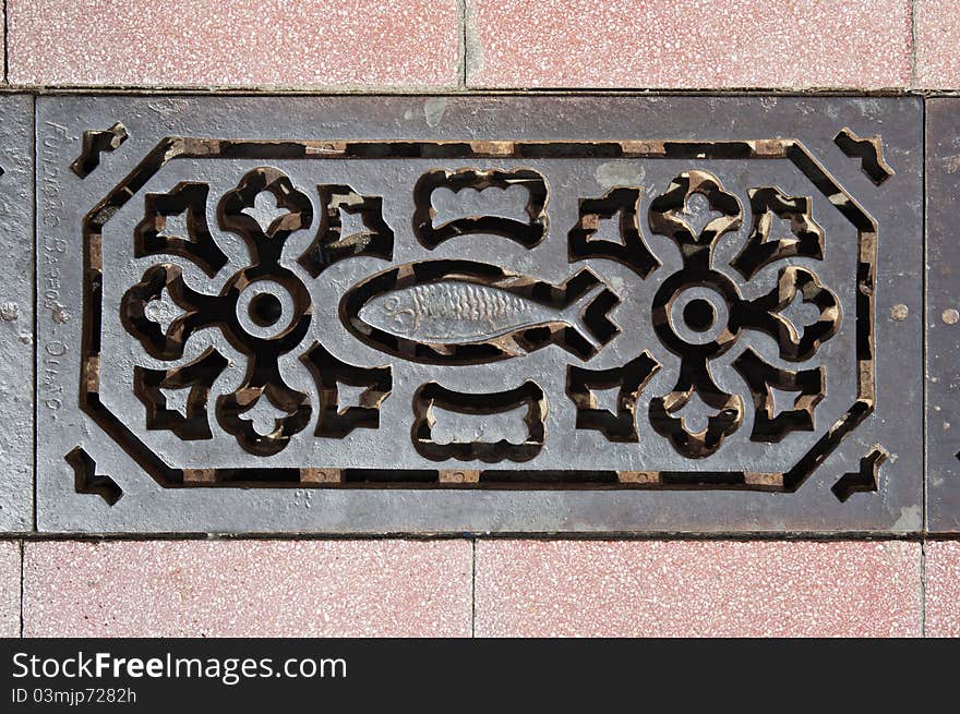 Decorated sewer grate in a street of Vila Real de Santo Antonio, Algarve, Portugal