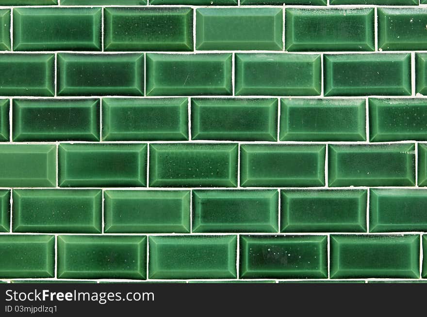 Closeup of a wall covered with green decorative tiles