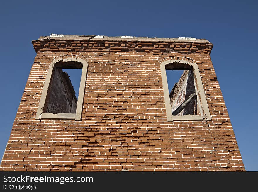 Ruins of a tower with brick walls against a blue clear sky. Ruins of a tower with brick walls against a blue clear sky