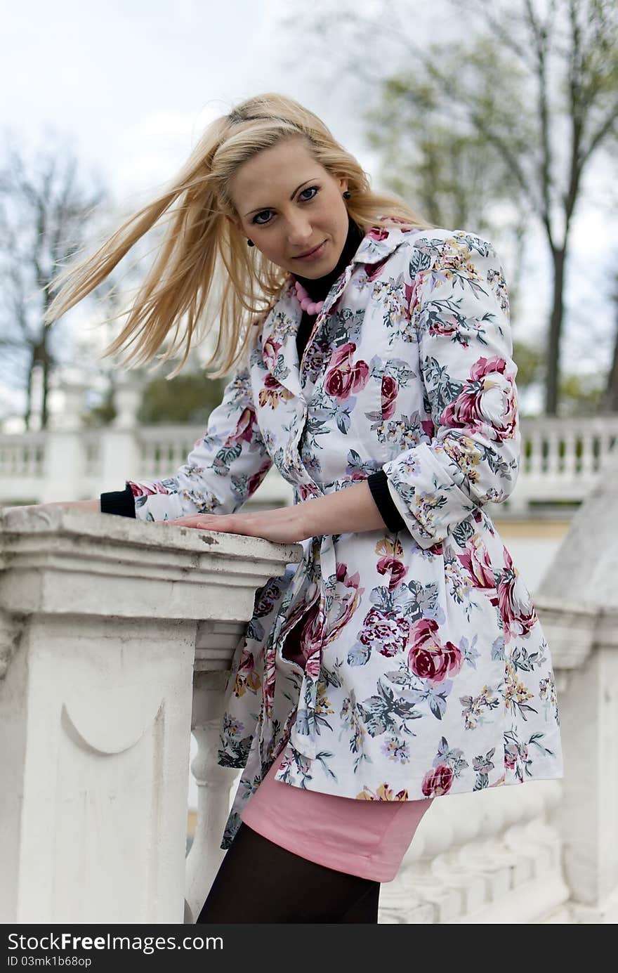 Blonde girl is leaning on old railing against the park. Blonde girl is leaning on old railing against the park