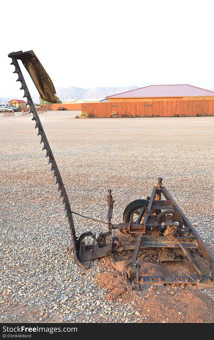 An antique piece of farm equipment used for cutting wheat or stalks. An antique piece of farm equipment used for cutting wheat or stalks.