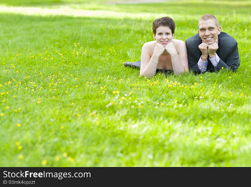 Happy Couple Lying On The Grass