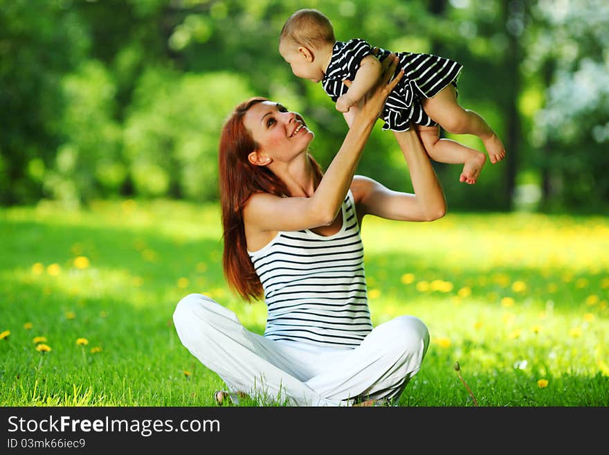 Happy mother and daughter on the green grass