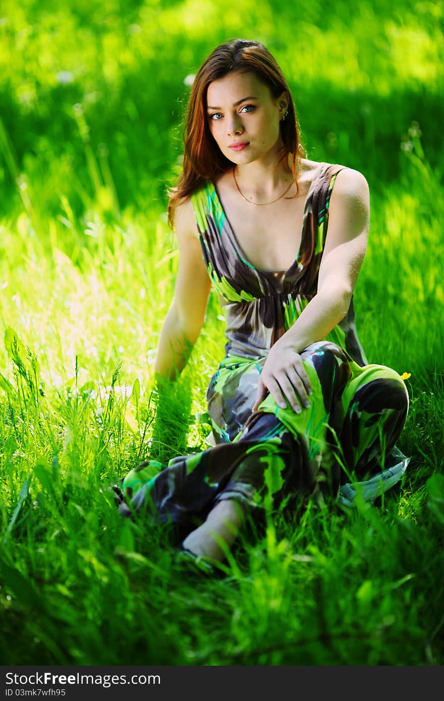 Brunette sitting on green grass