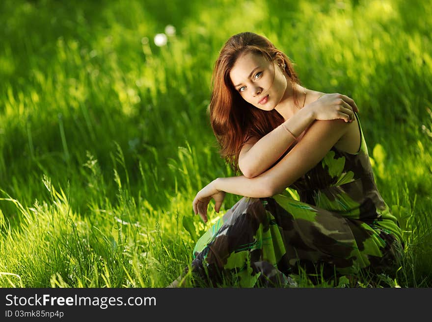 Brunette sitting on green grass