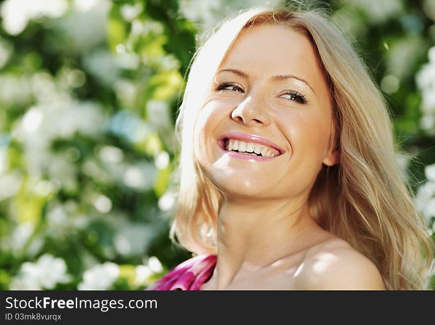 Happy girl near a tree on a summer day