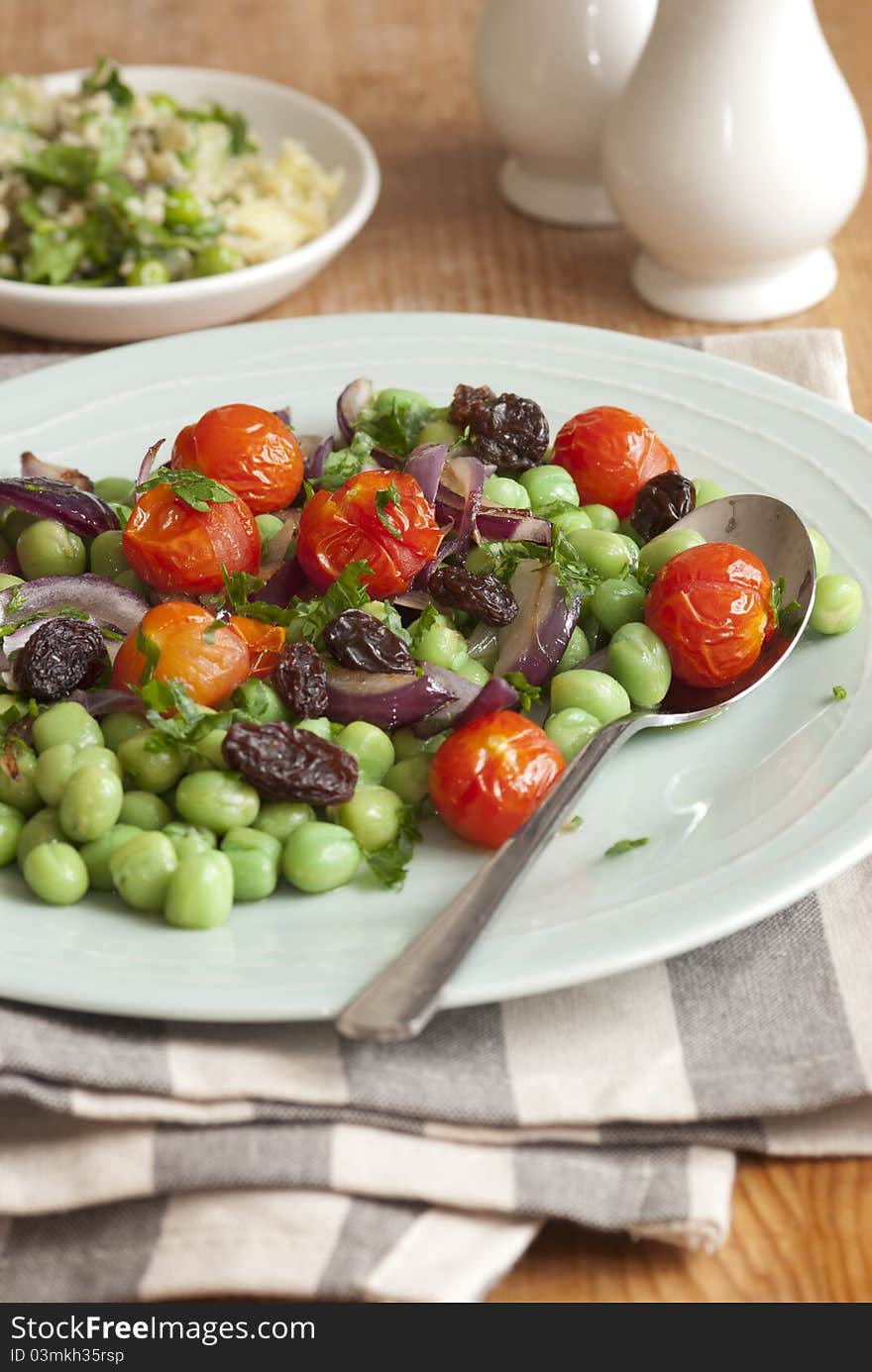 Broad bean, cherry tomato and raisin salad on a plate. Broad bean, cherry tomato and raisin salad on a plate