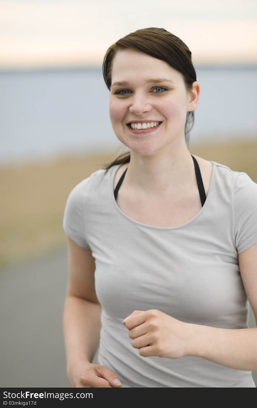 Beautiful young woman jogging on the beach