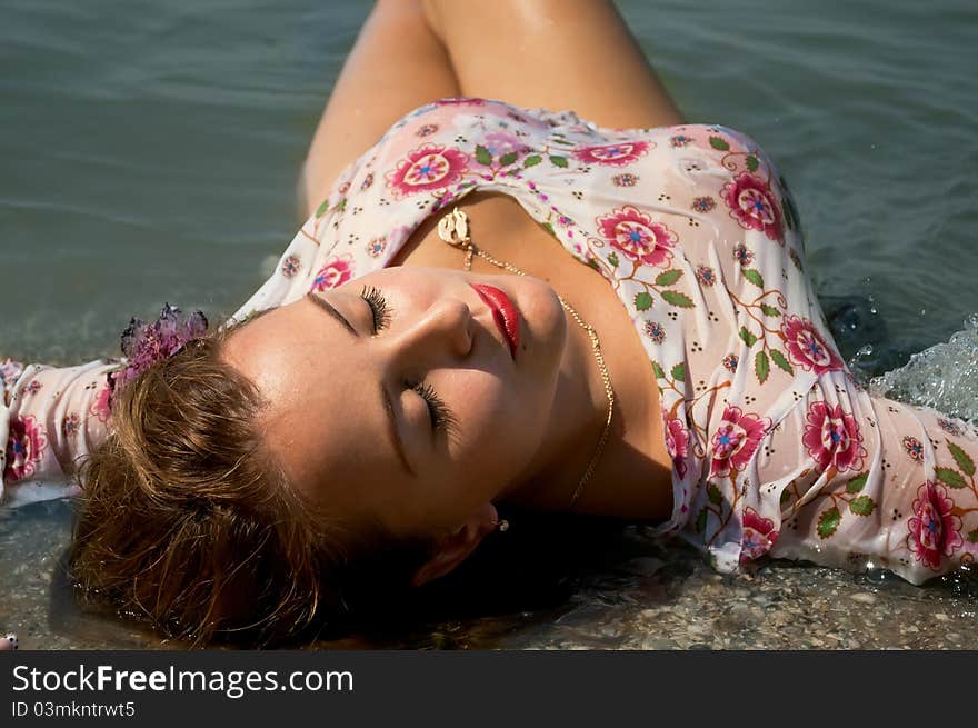 The woman lies ashore in water