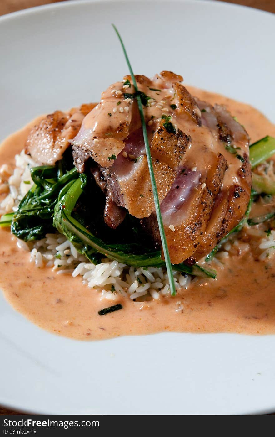 Grilled duck over greens and wild rice. Grilled duck over greens and wild rice