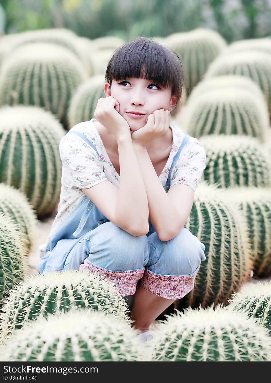 Charming Asian girl posing in ball cactus field. Charming Asian girl posing in ball cactus field.