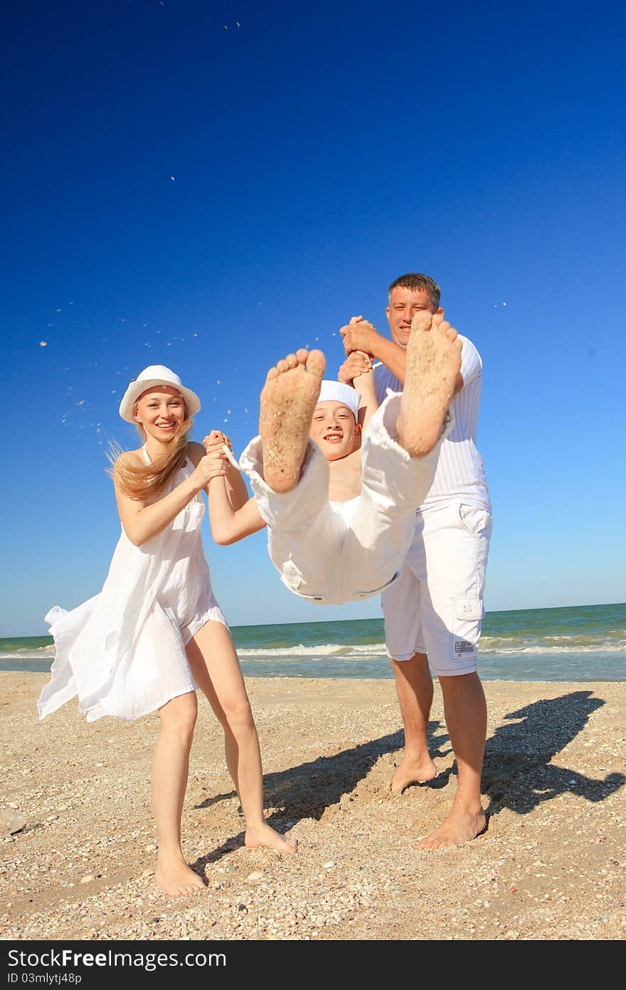 Boy flying on his parent's hands at beach. Boy flying on his parent's hands at beach