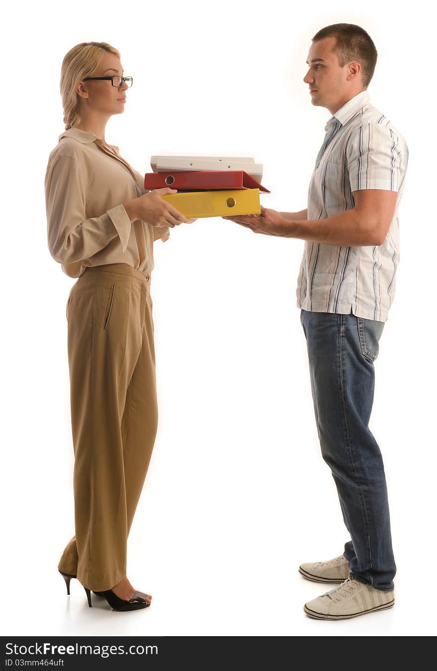 Man and woman standing face to face while holding pile of office binders