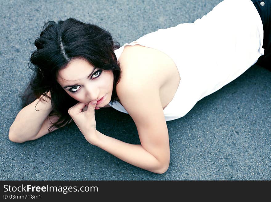 Attractive young woman lying on a gray background. Attractive young woman lying on a gray background