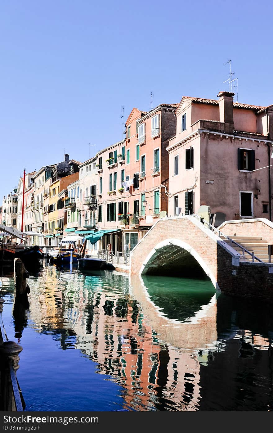 Bridge reflected in the water in Venice (Italy)