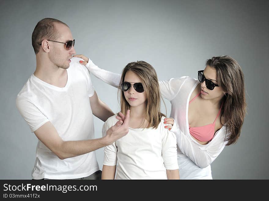 Pretty young people posing with sunglasses in studio. Pretty young people posing with sunglasses in studio