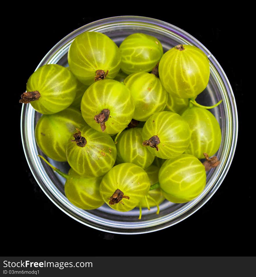 Gooseberries in a white bowl on black