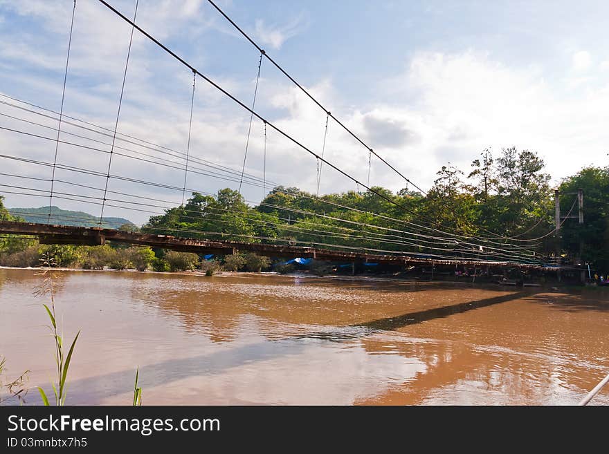 Wooden suspension bridge cross the river from side. Wooden suspension bridge cross the river from side