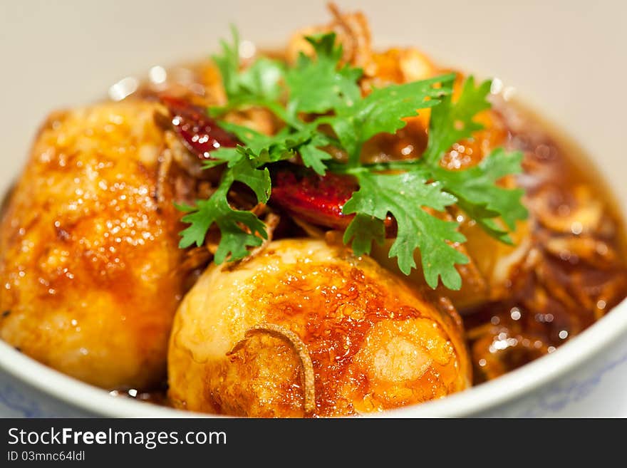 Fried eggs topped with sweet sauce on white background