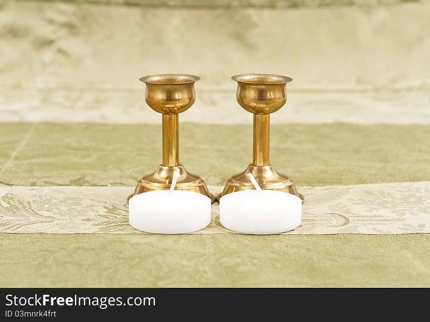 Bronze Candle Holders With Small Candles On Fancy Table Cloth Background