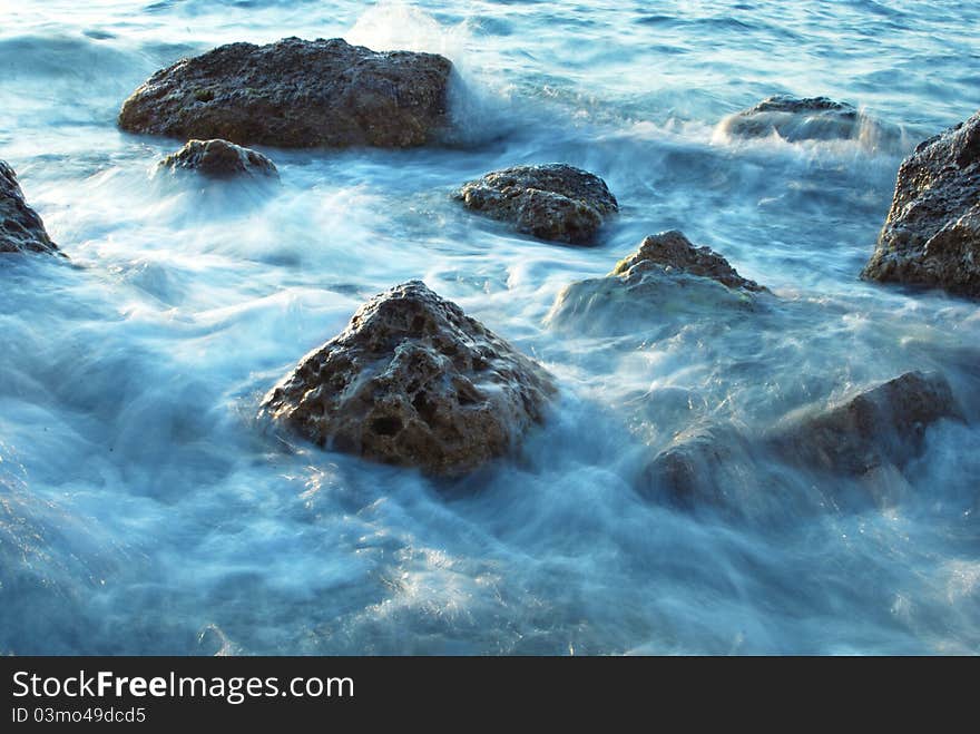 Stones in sea, waves of evening flow. Stones in sea, waves of evening flow