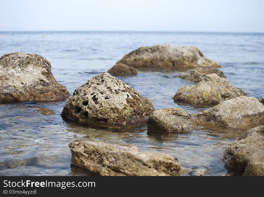 Several stones in Black sea, blurred water near the coast. Several stones in Black sea, blurred water near the coast