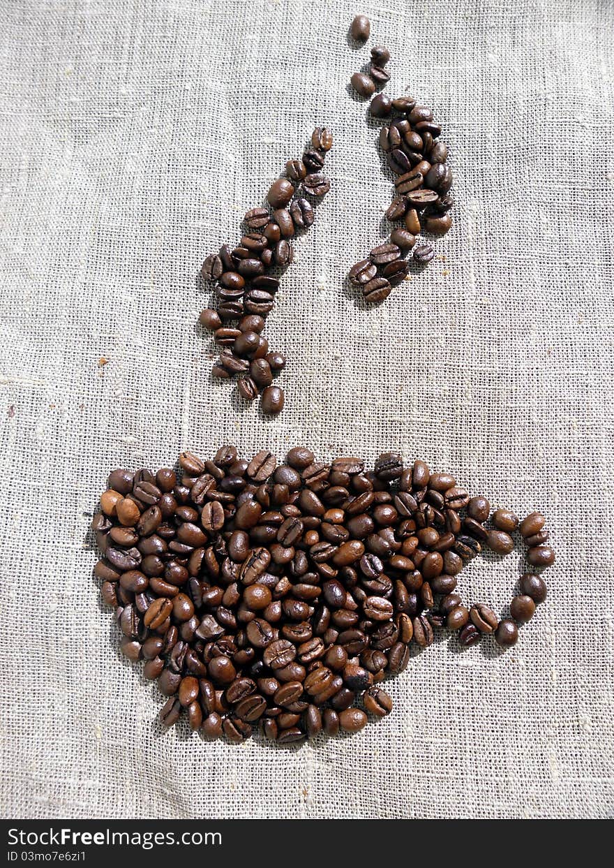 A picture of a cup of coffee made from coffee beans, on linen cloth.