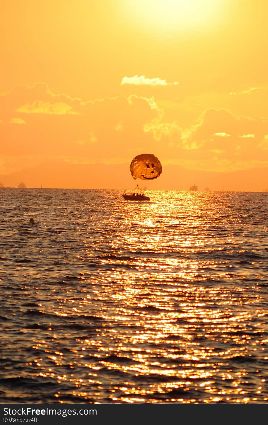 Boat with a parachute at sunset