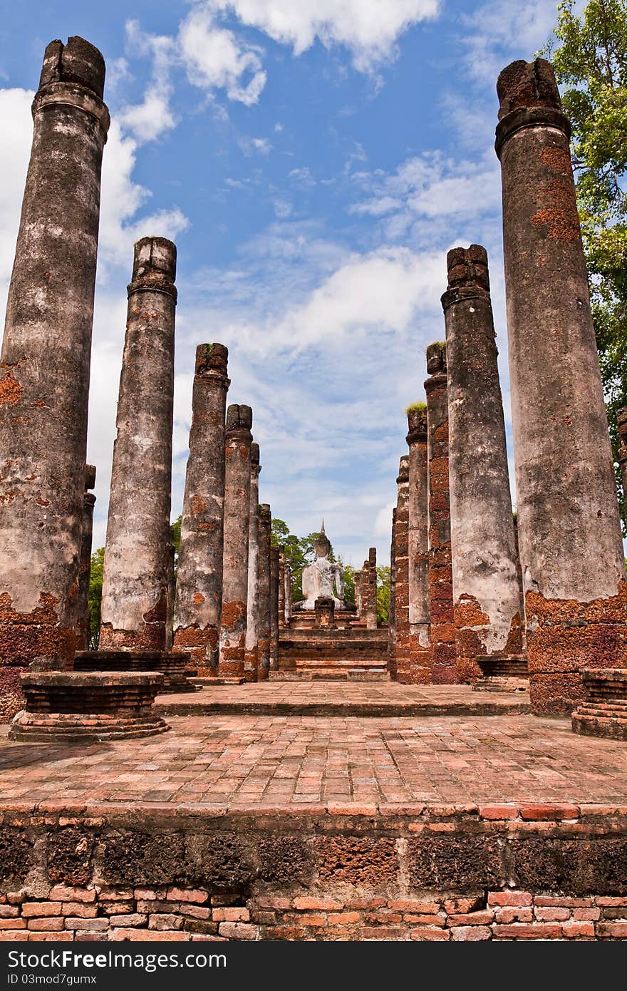 Buddha Statue Among Pillars From Back