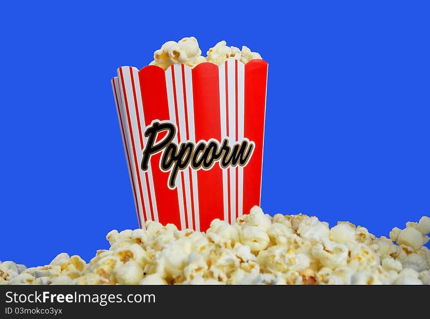 Container of popcorn on top of a pile of the snack. Container of popcorn on top of a pile of the snack