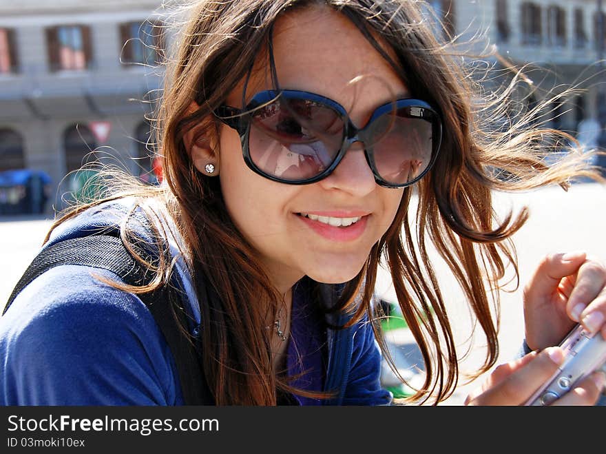 Teenage girl in sunglasses with camera smiling outdoor