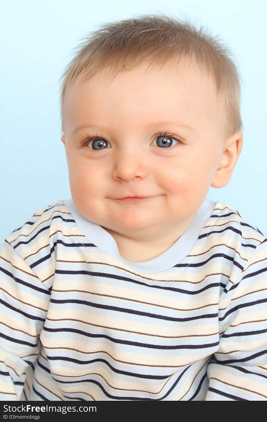 Beautiful 6 month old baby boy against blue background