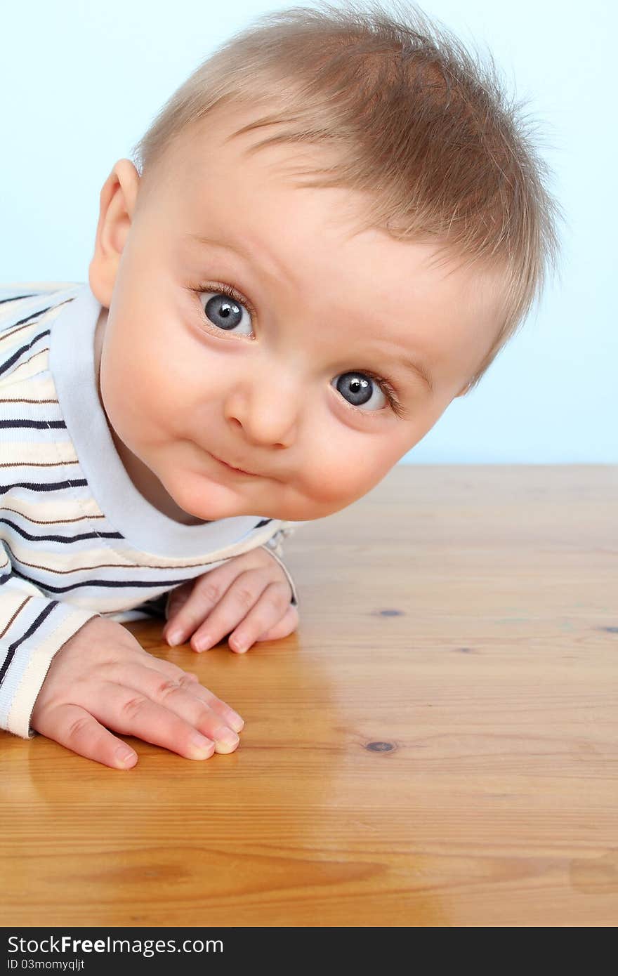 Beautiful 6 month old baby boy against blue background