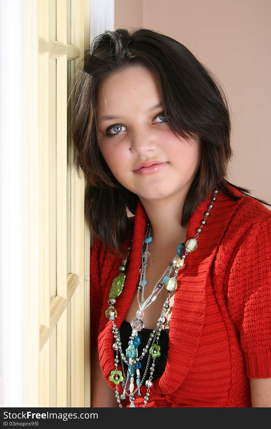 Beautiful brunette female leaning against a door on a sunny day. Beautiful brunette female leaning against a door on a sunny day