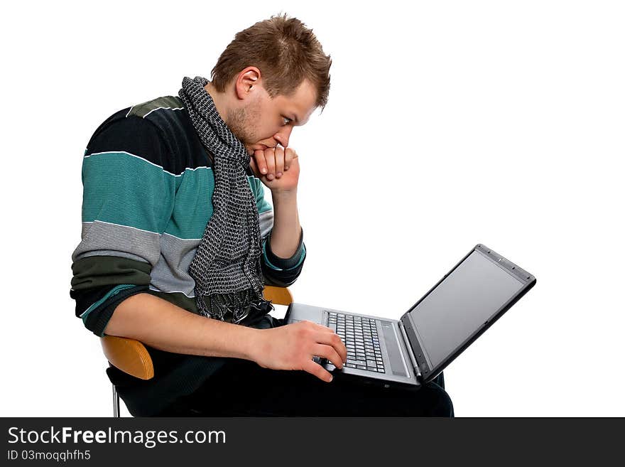 Young man with laptop sitting poses in the studio on a white background