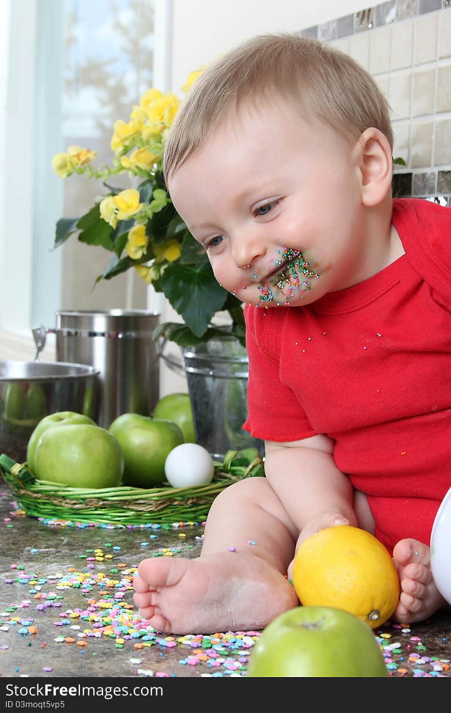 Baby boy playing on messy counter top. Baby boy playing on messy counter top